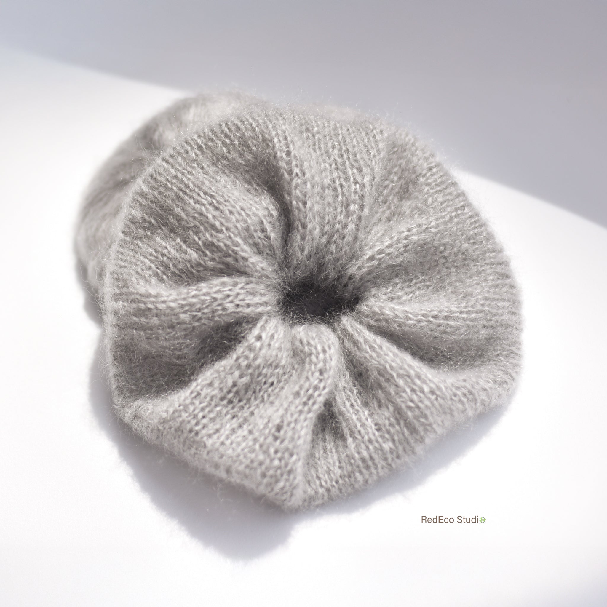 extra large light grey hand knitted scrunchie on a light background