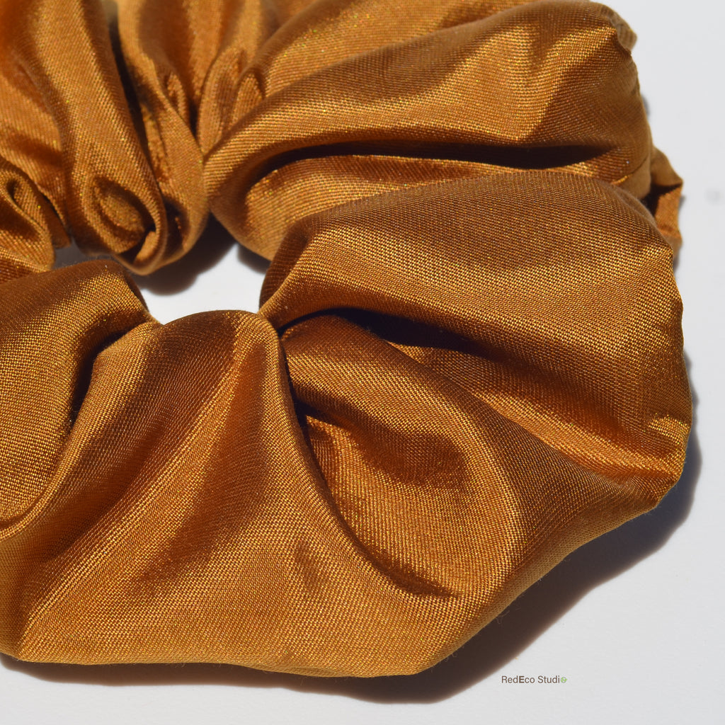 Close-up of a mustard yellow scrunchie on a white background