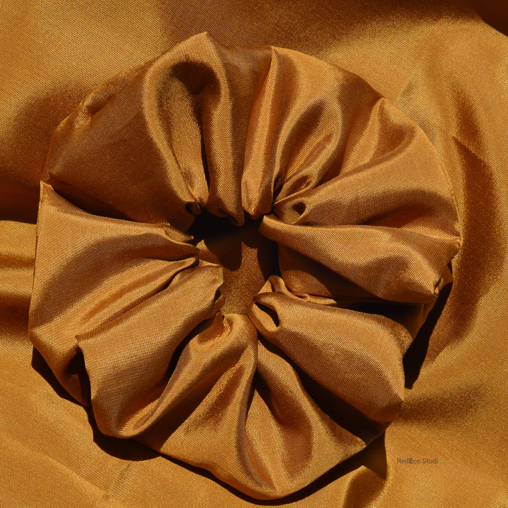 Brown scrunchie on a matching brown fabric background