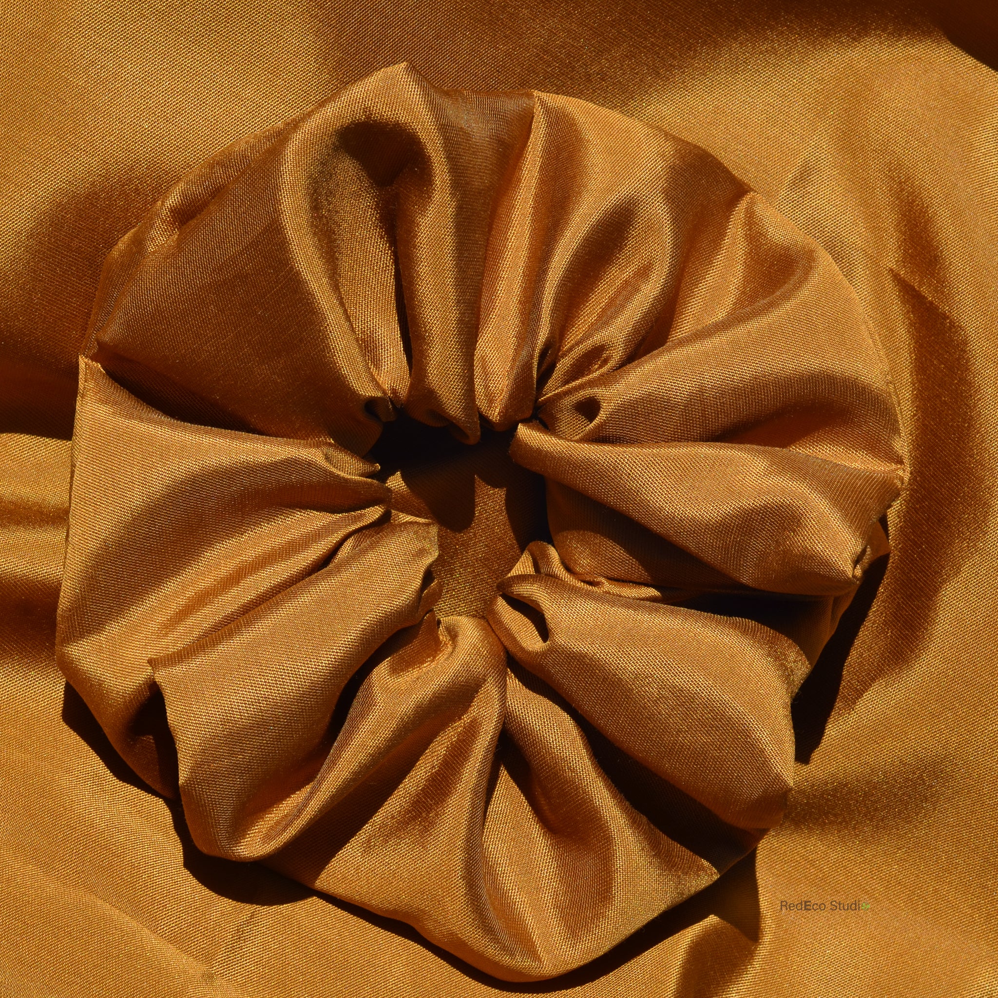Brown scrunchie on a matching brown fabric background
