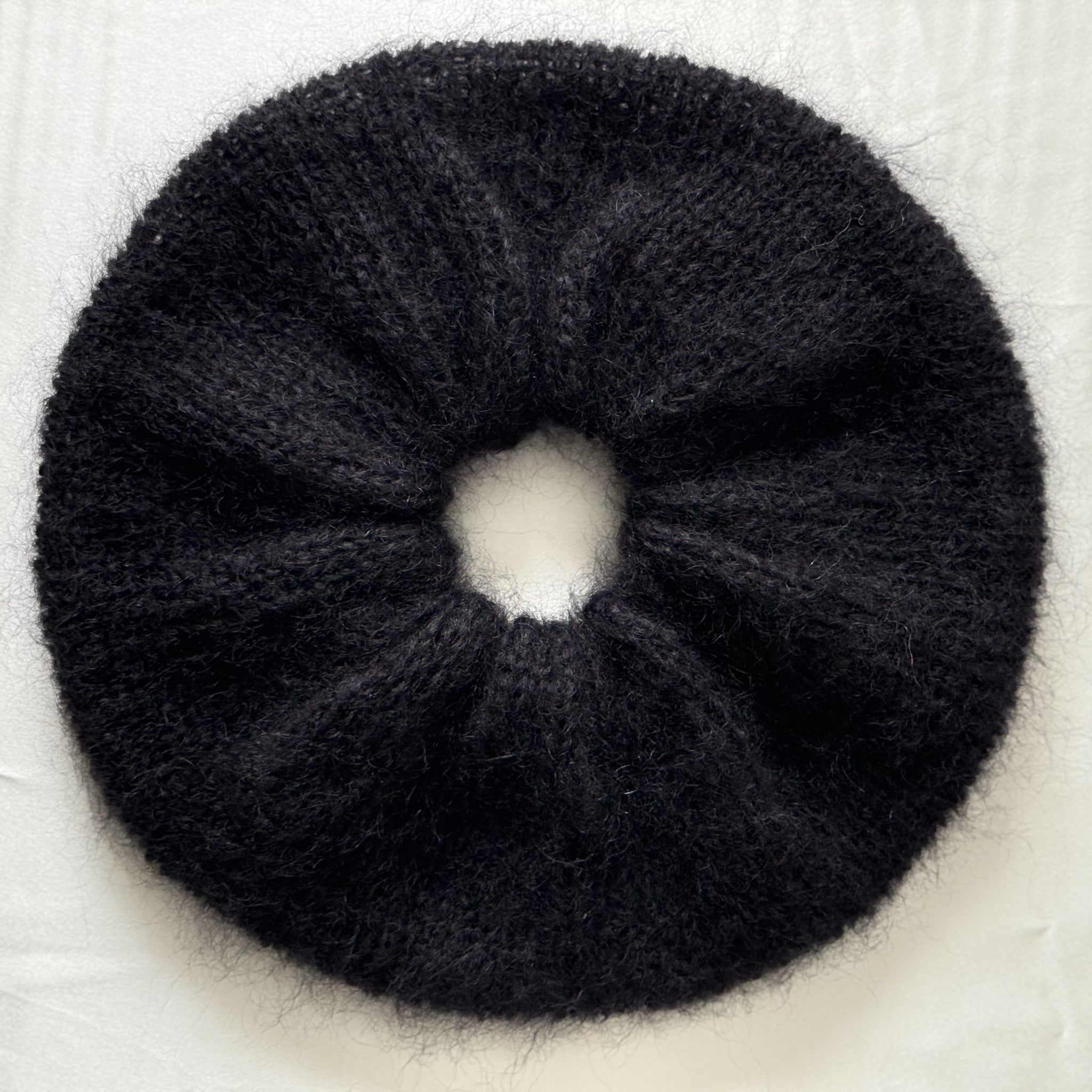 Black extra large hand-knitted scrunchie on a light background.