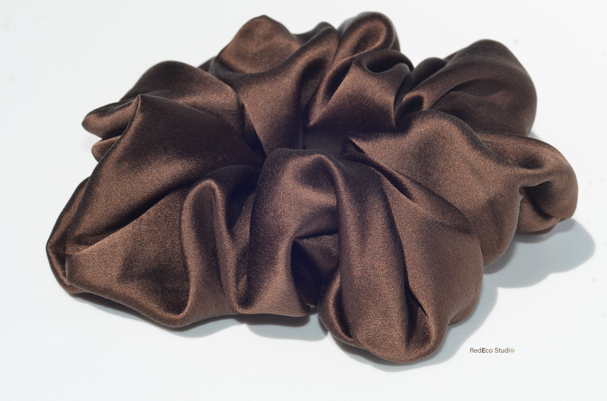 Brown satin scrunchie on a white background