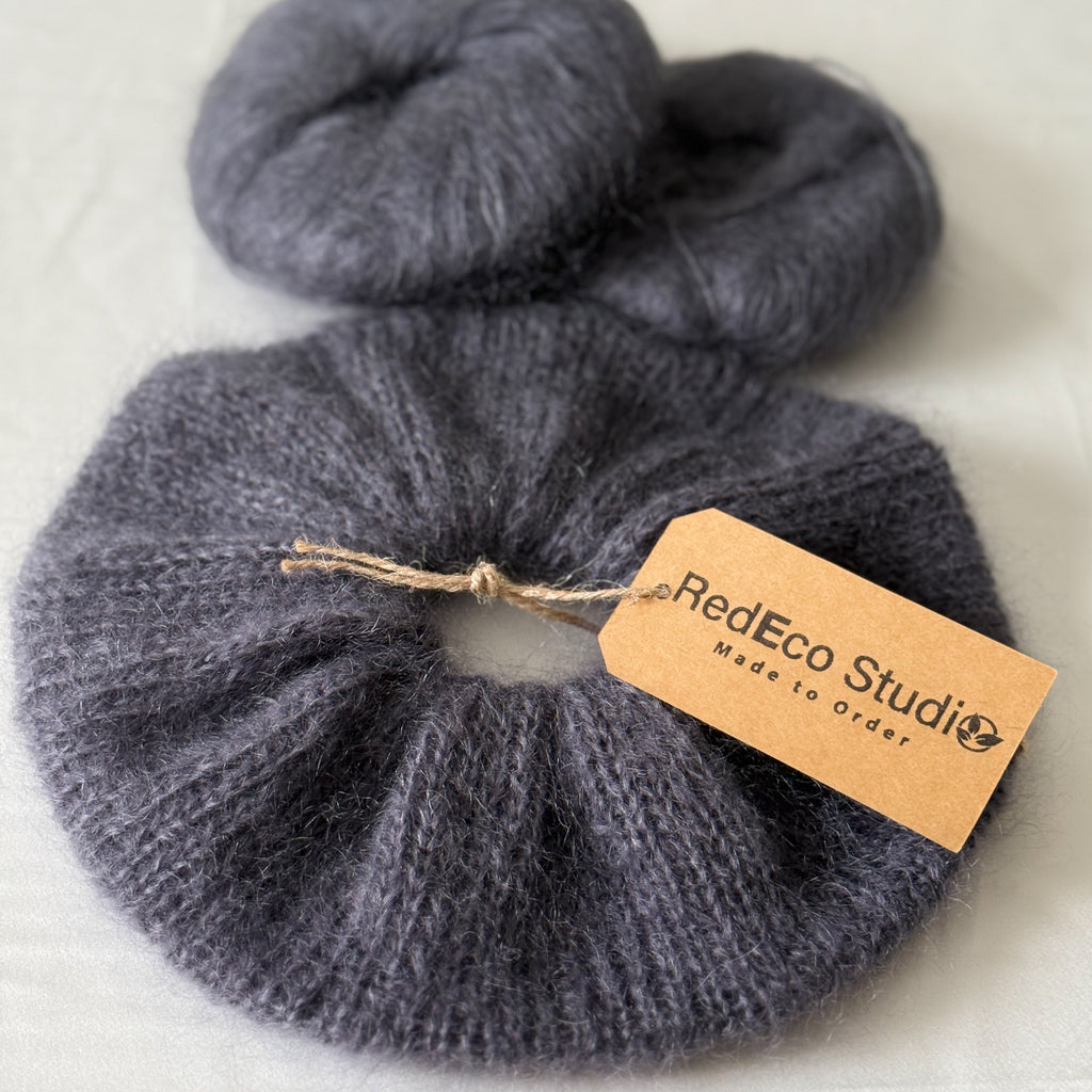 dark gray hand-knitted scrunchie on a light background