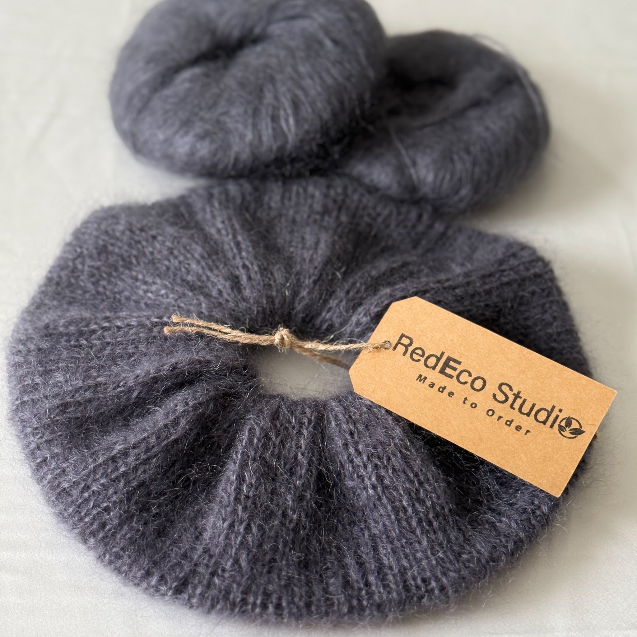 dark gray hand-knitted scrunchie on a light background