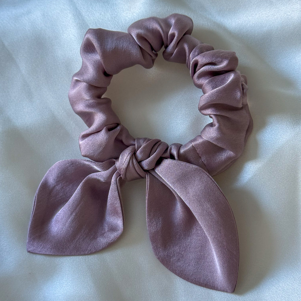 Purple scrunchie with a bow on a light background