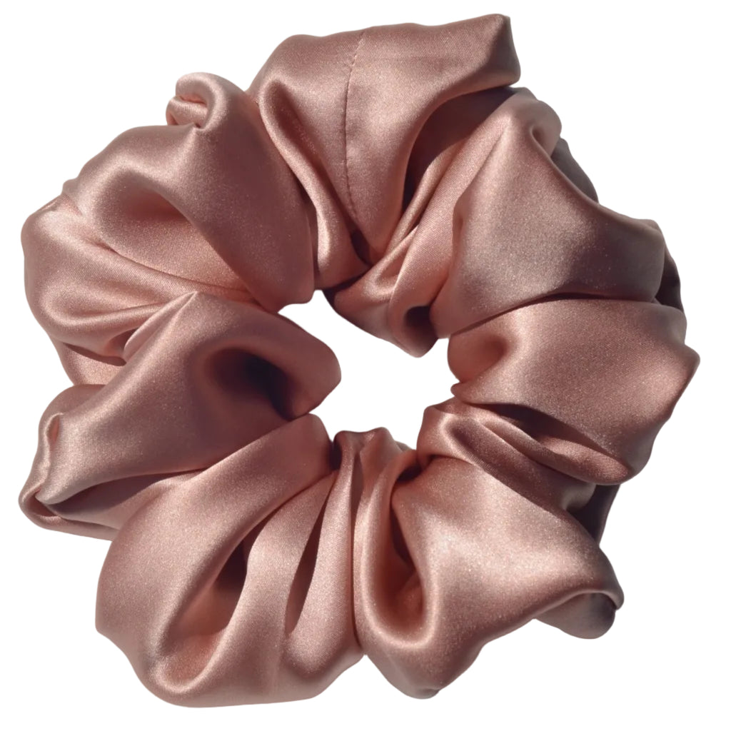 Pink satin scrunchie on a light gray background