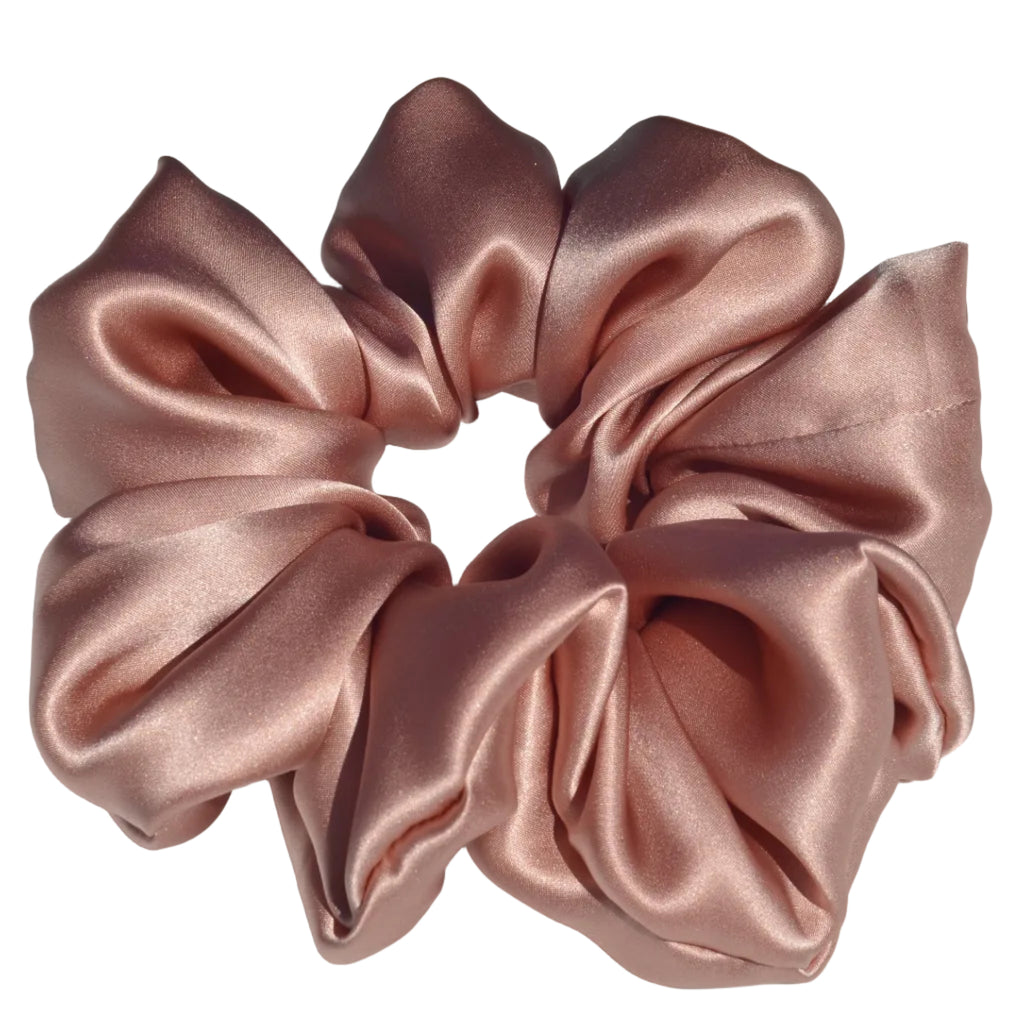 Pink satin scrunchie on a light gray background