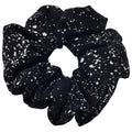 Large black silk scrunchie with white speckles on a light gray background