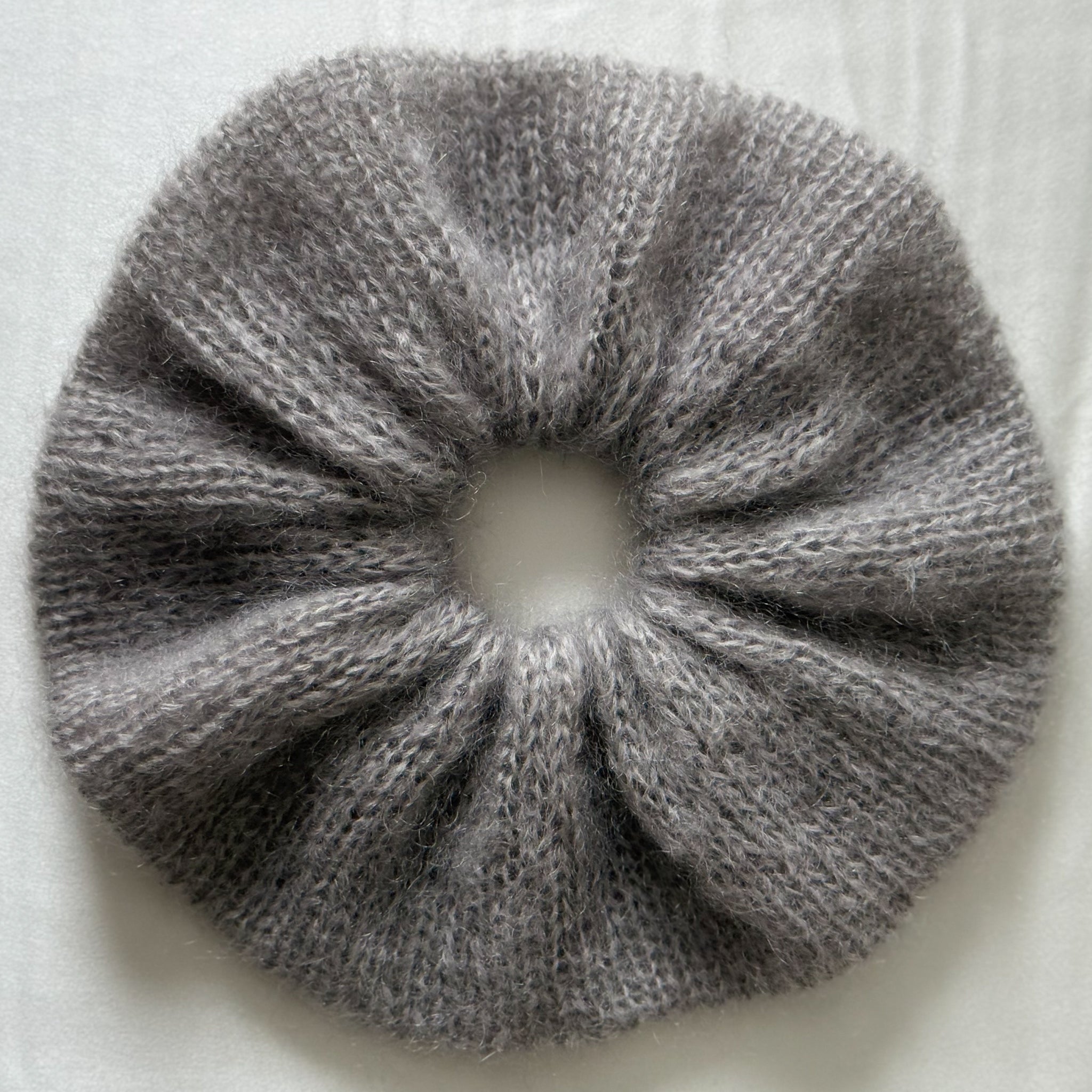 Light Grey knitted scrunchie on a light background.