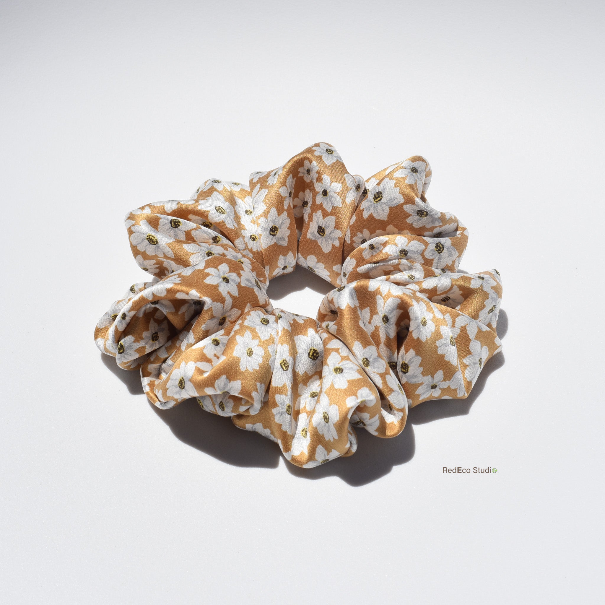 Large floral patterned silk scrunchie on a white background