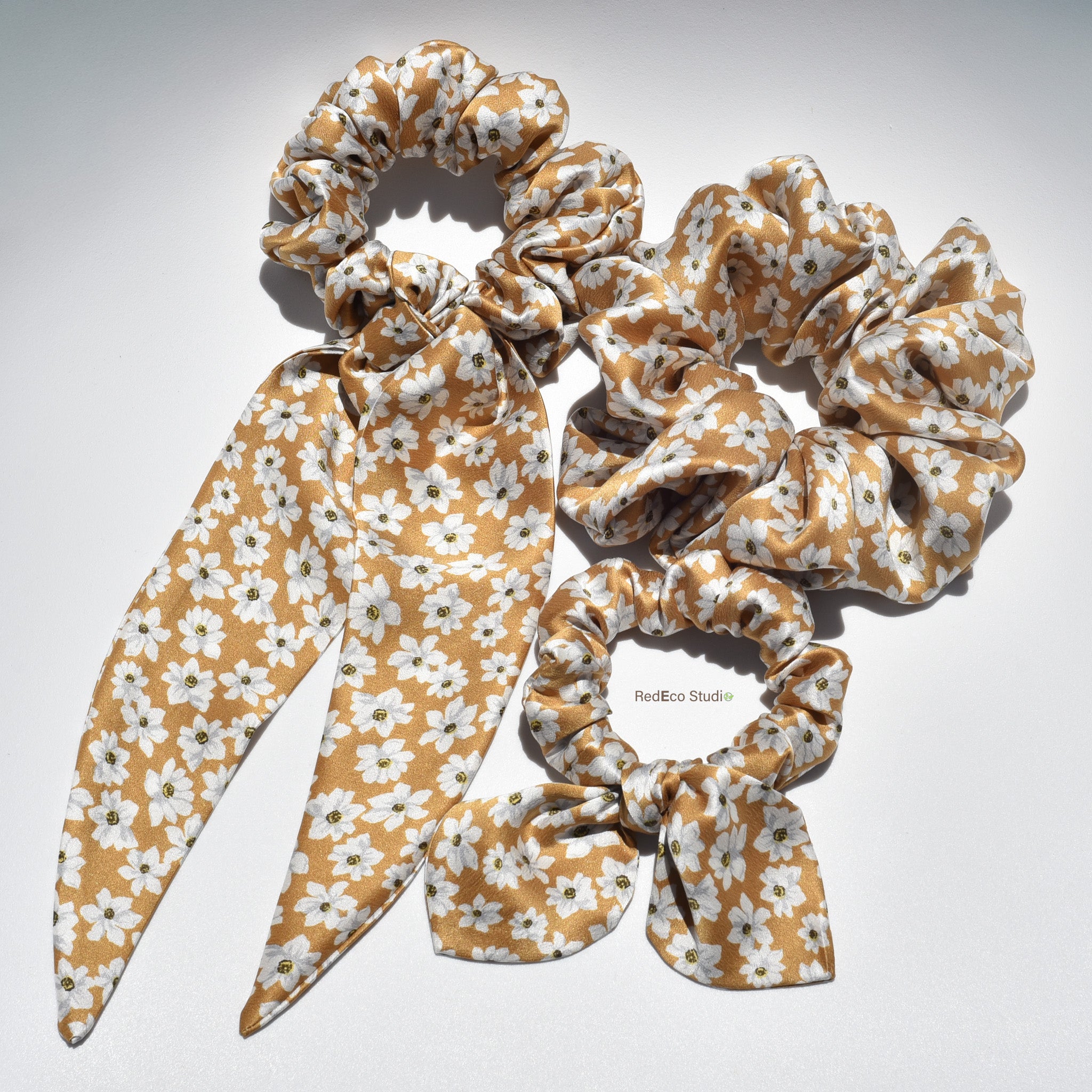 Set of floral-patterned silk scrunchies on a light gray background