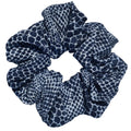 Navy blue scrunchie with white pattern on a light gray background