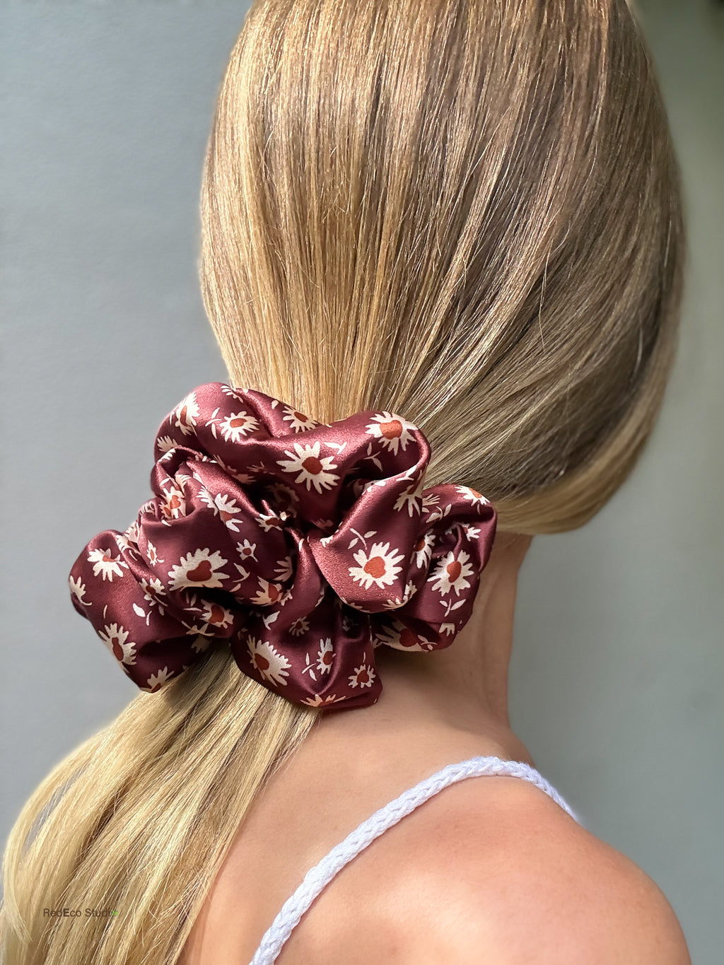 Close-up of the Merlot Daisy oversized pure silk scrunchie on a low ponytail, showing its size and full gathers
