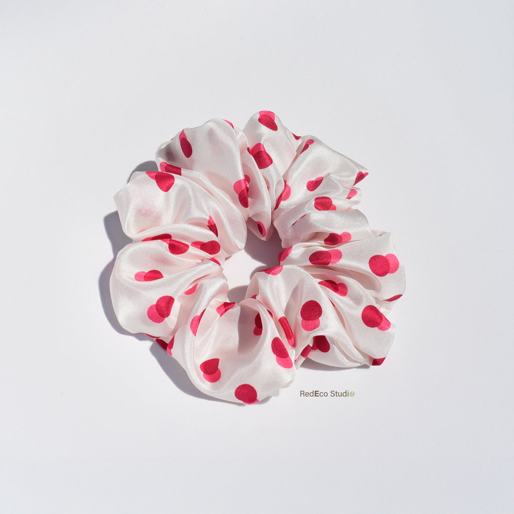 White silk scrunchie with two-tone red spots on a white background