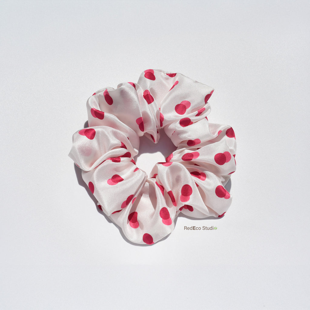 White silk scrunchie with two-tone red spots on a white background