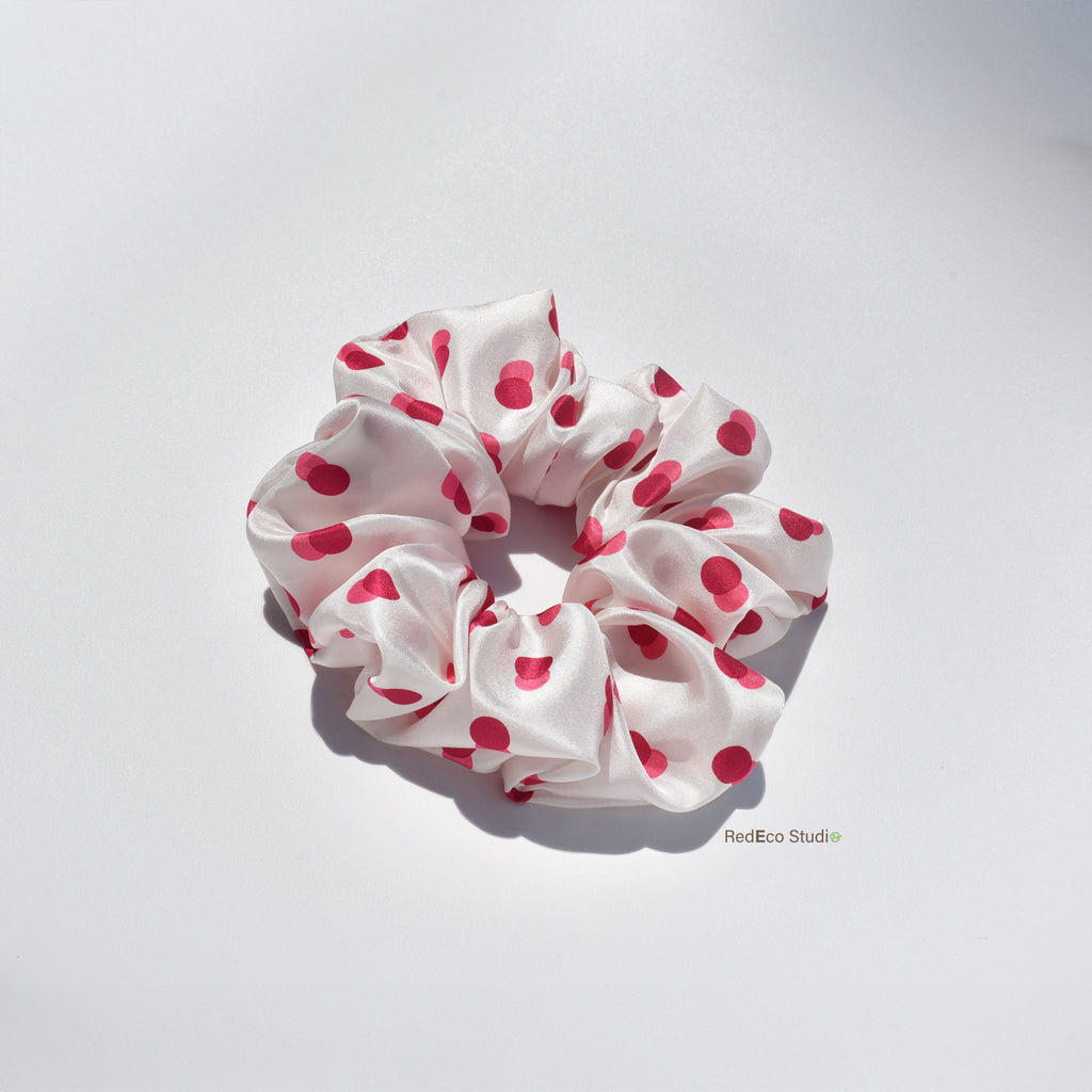 White silk scrunchie with two-tone red spots on a white background