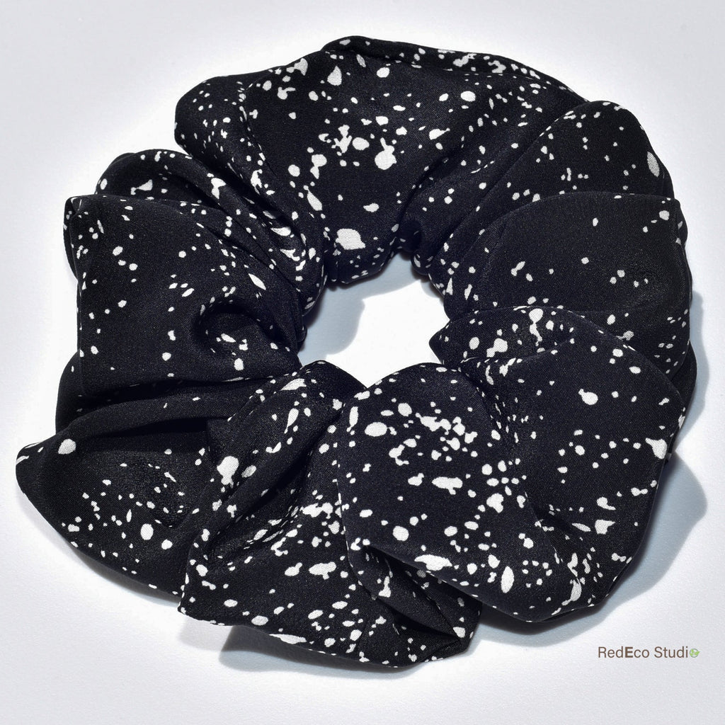 Black scrunchie with white speckles on a light gray background