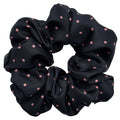 Black scrunchie with pink polka dots on a white background