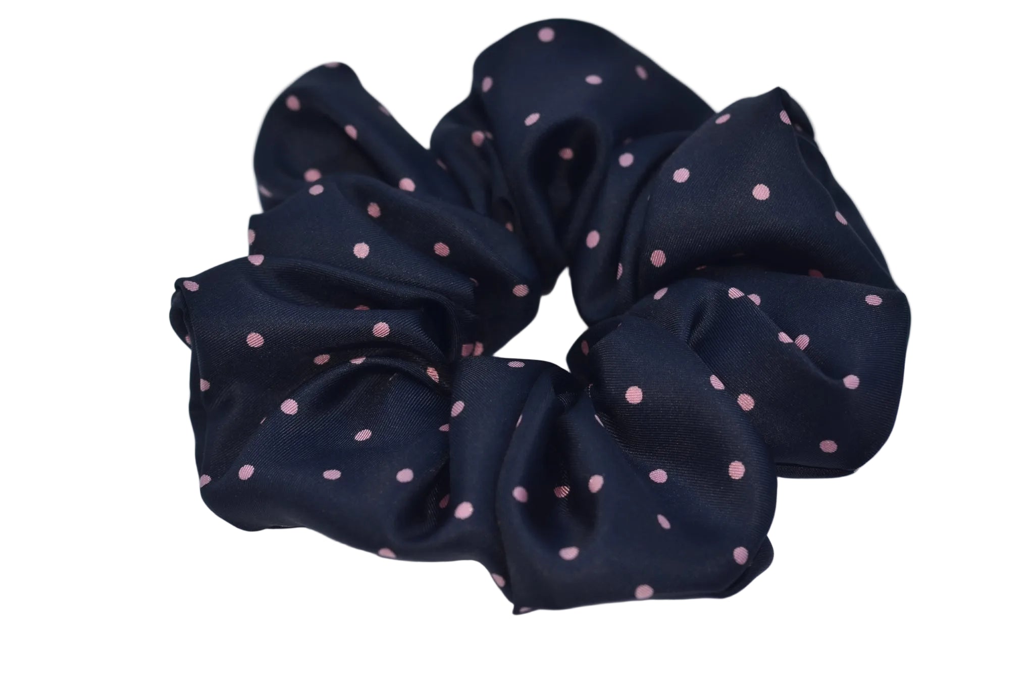 Black scrunchie with pink polka dots on a light blue background
