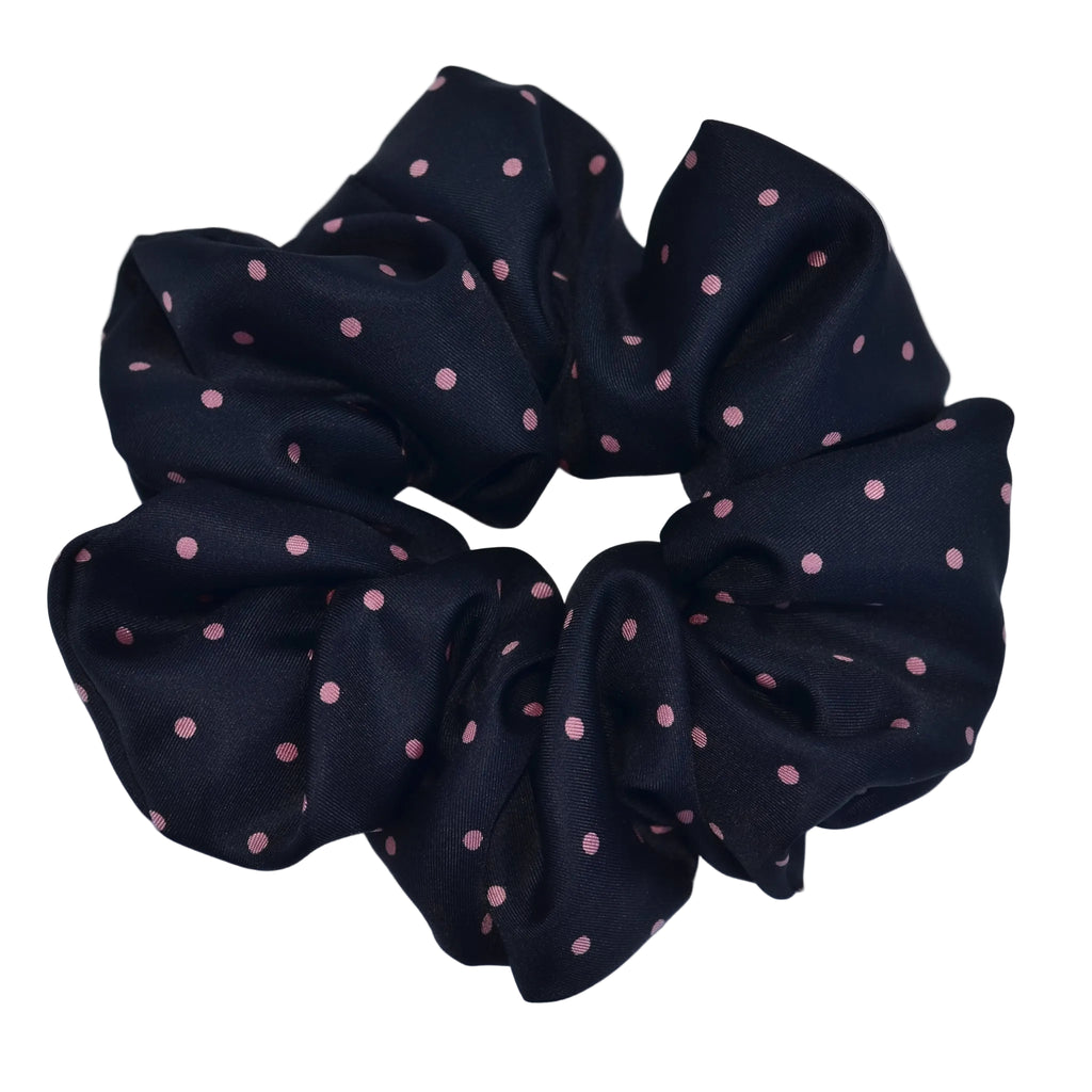 Black scrunchie with pink polka dots on a light blue background