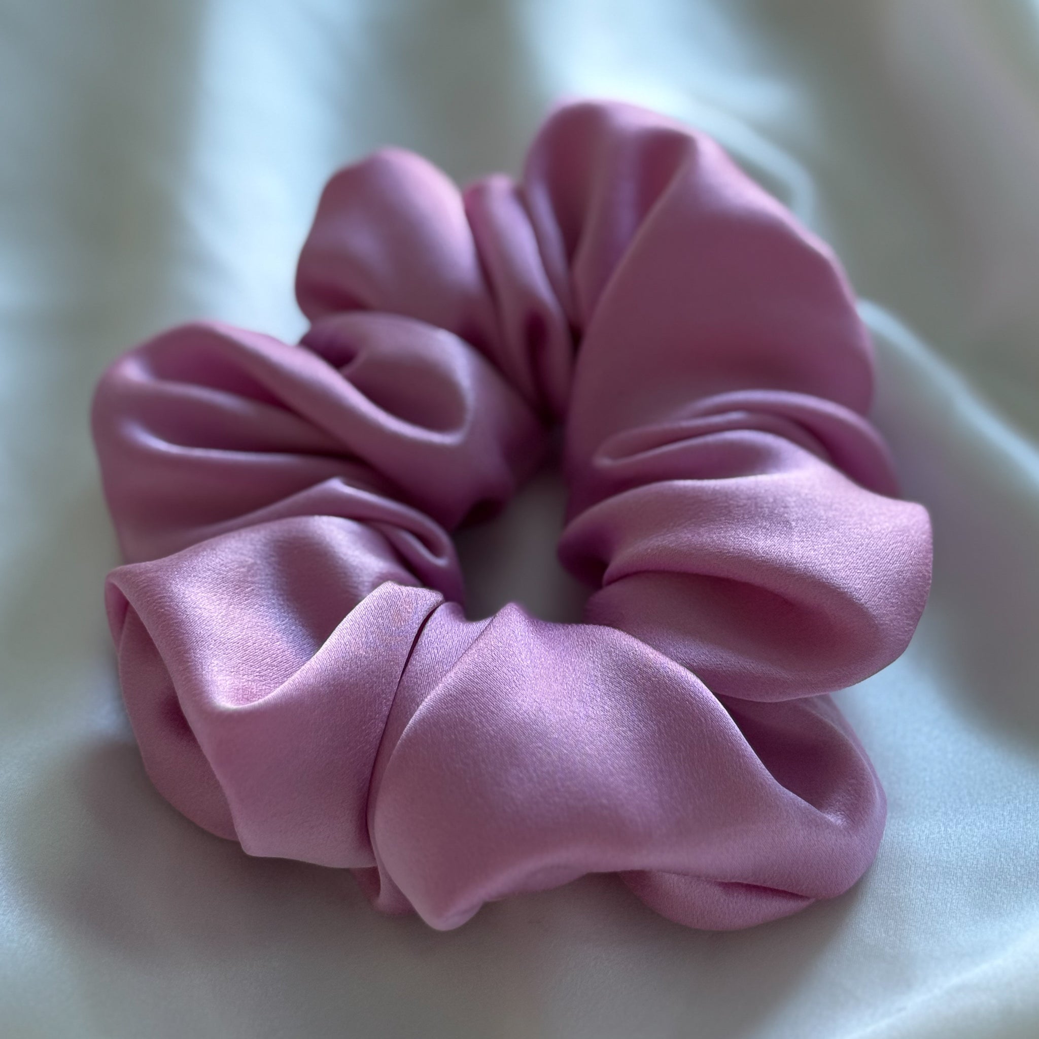 Pink silk scrunchie on a white background