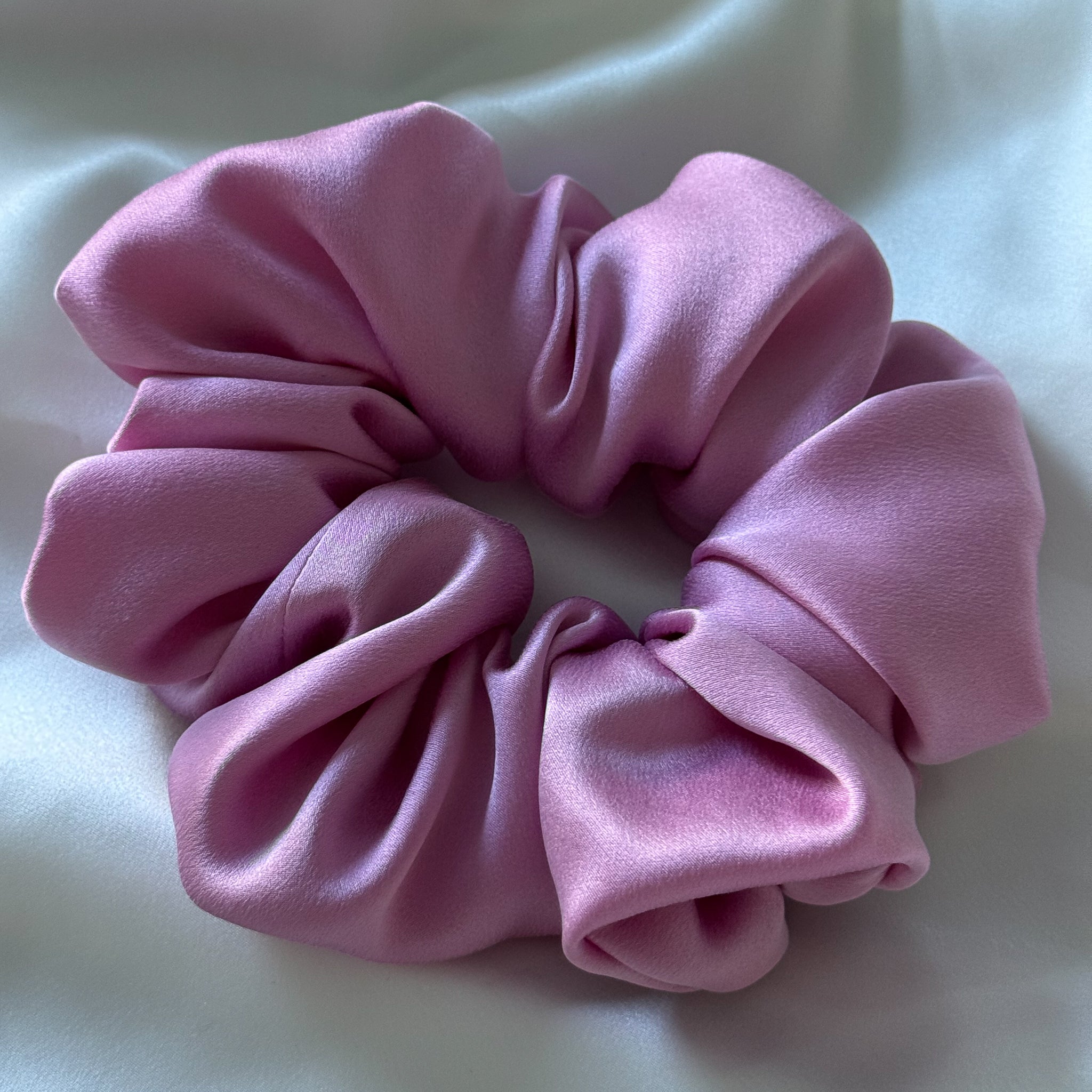 Oversized Pink scrunchie on a white fabric background