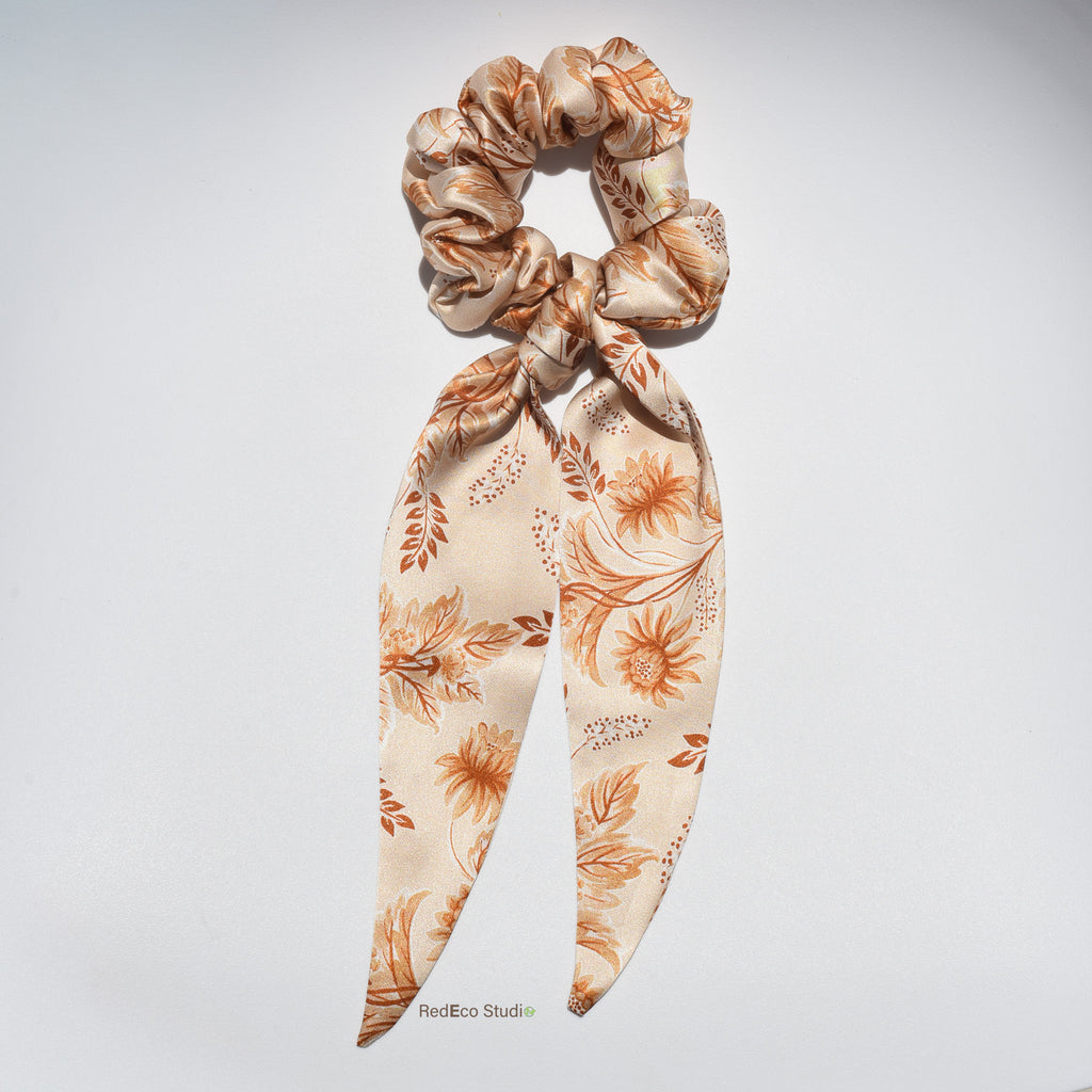 Floral patterned silk long tail scrunchie on a light gray background