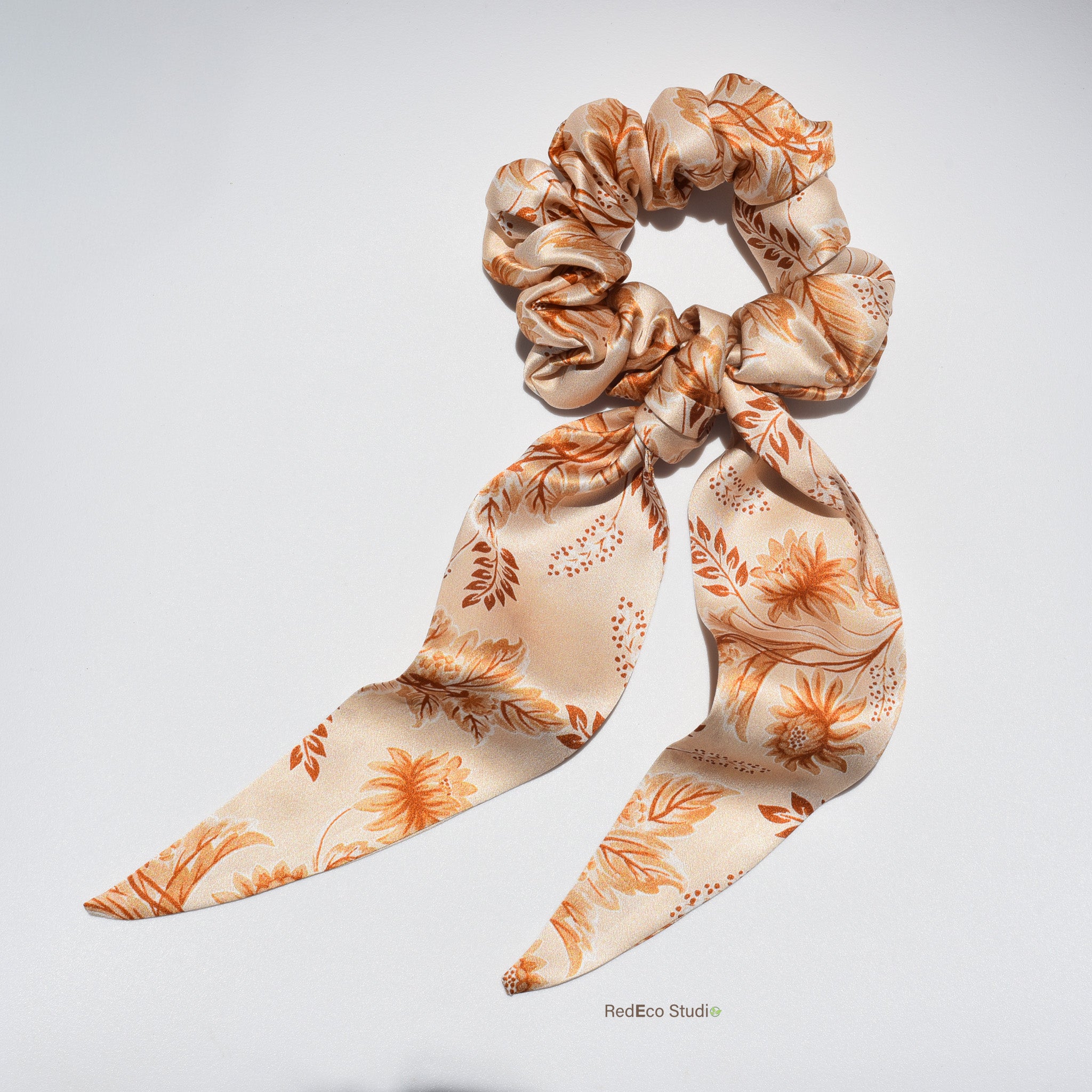 Floral patterned pure silk long tail scrunchie on a light gray background