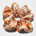 Floral patterned silk scrunchie on a white background