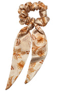 Floral patterned scrunchie with bow on a light gray background
