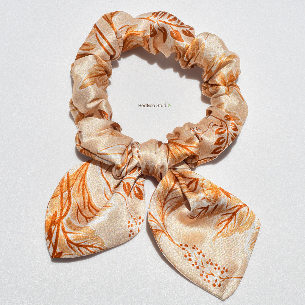 Floral patterned silk bow scrunchie on a white background