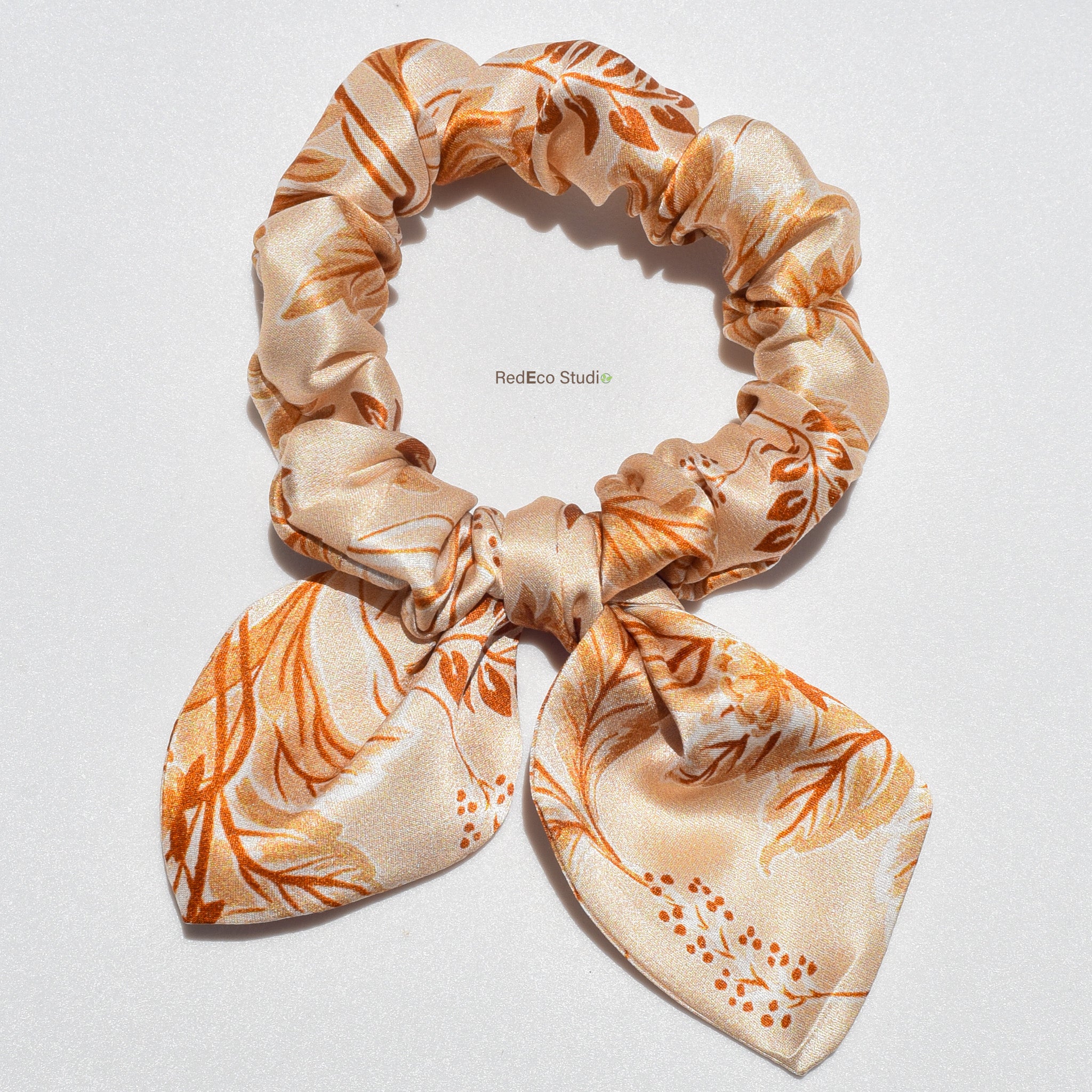 Floral patterned silk bow scrunchie on a white background