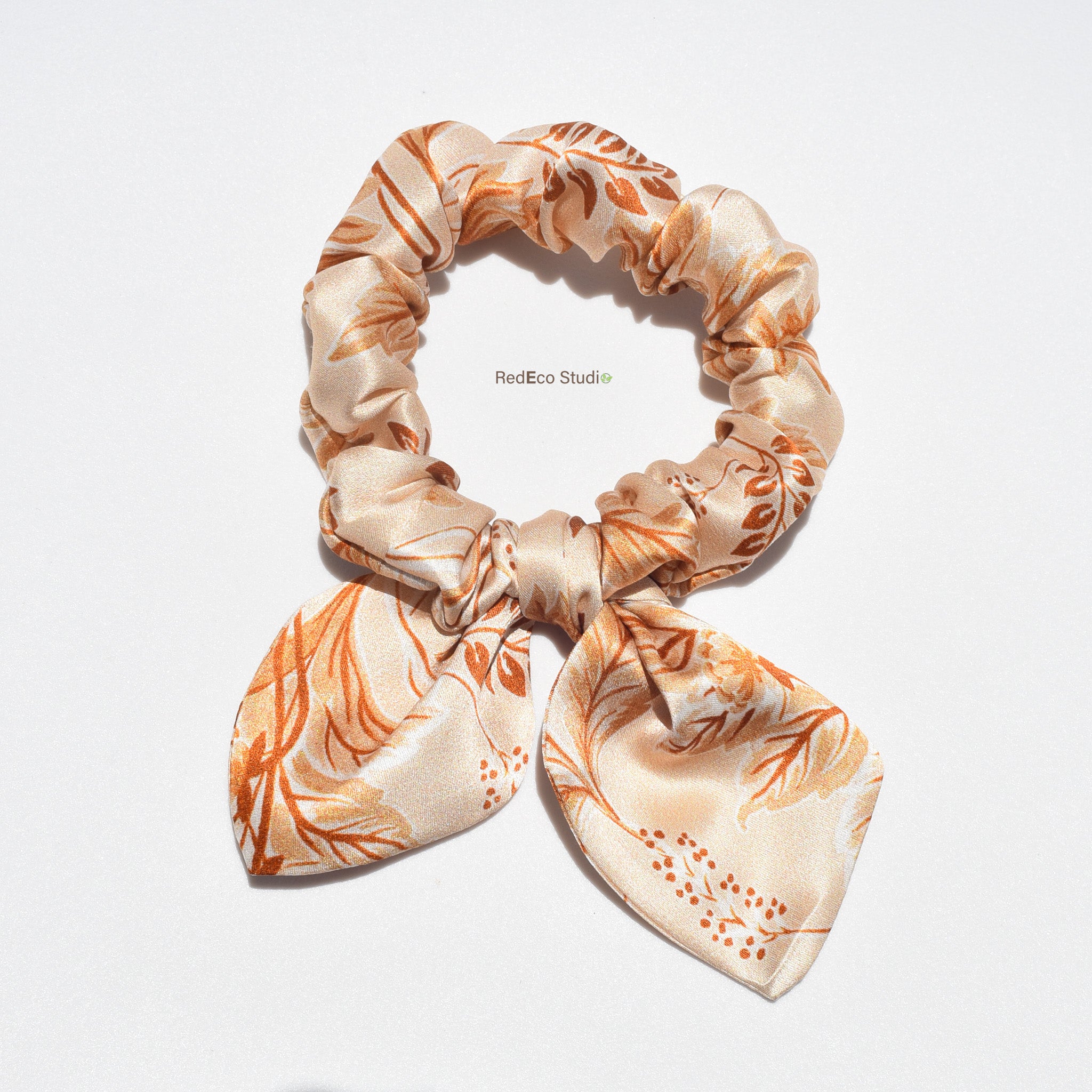 Floral patterned silk bow scrunchie on a white background