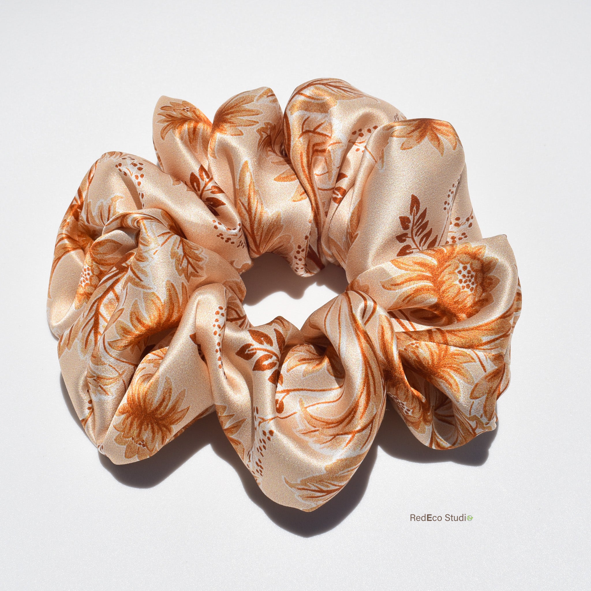 Floral patterned silk scrunchie on a white background