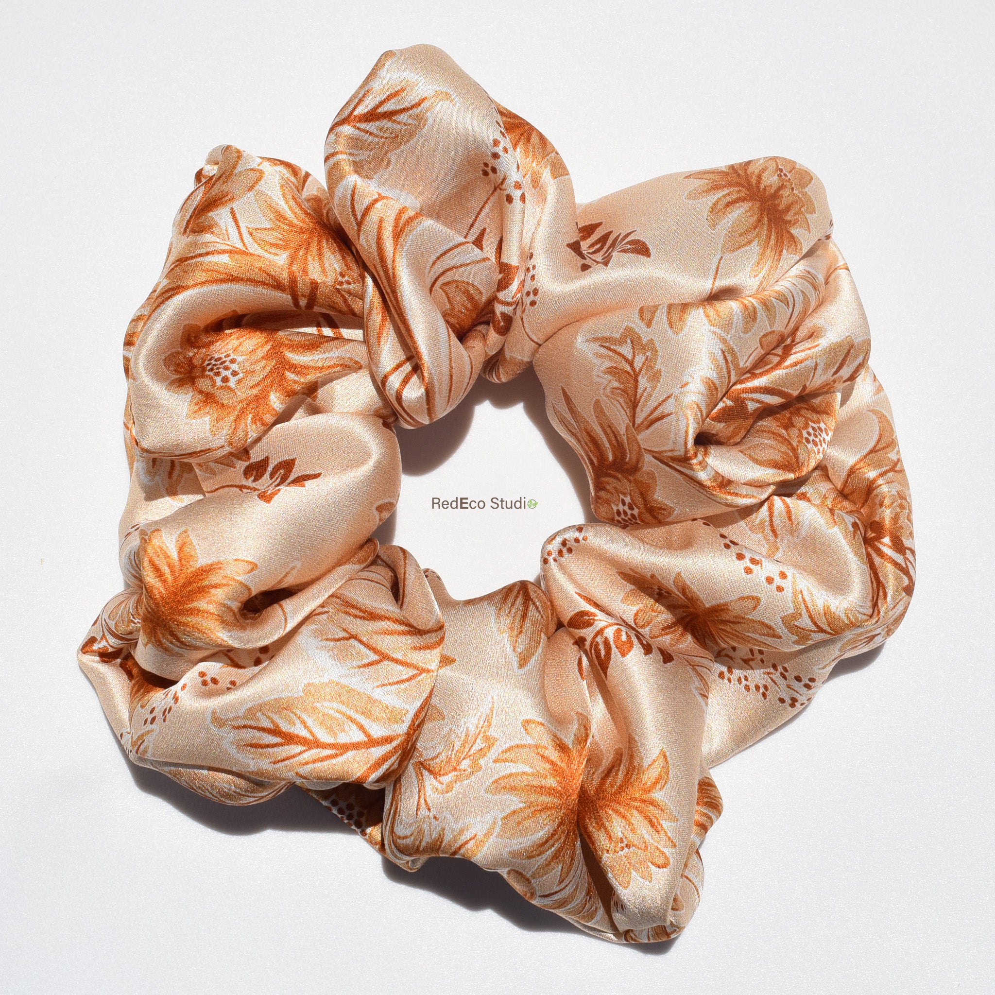 Floral patterned silk scrunchie on a white background