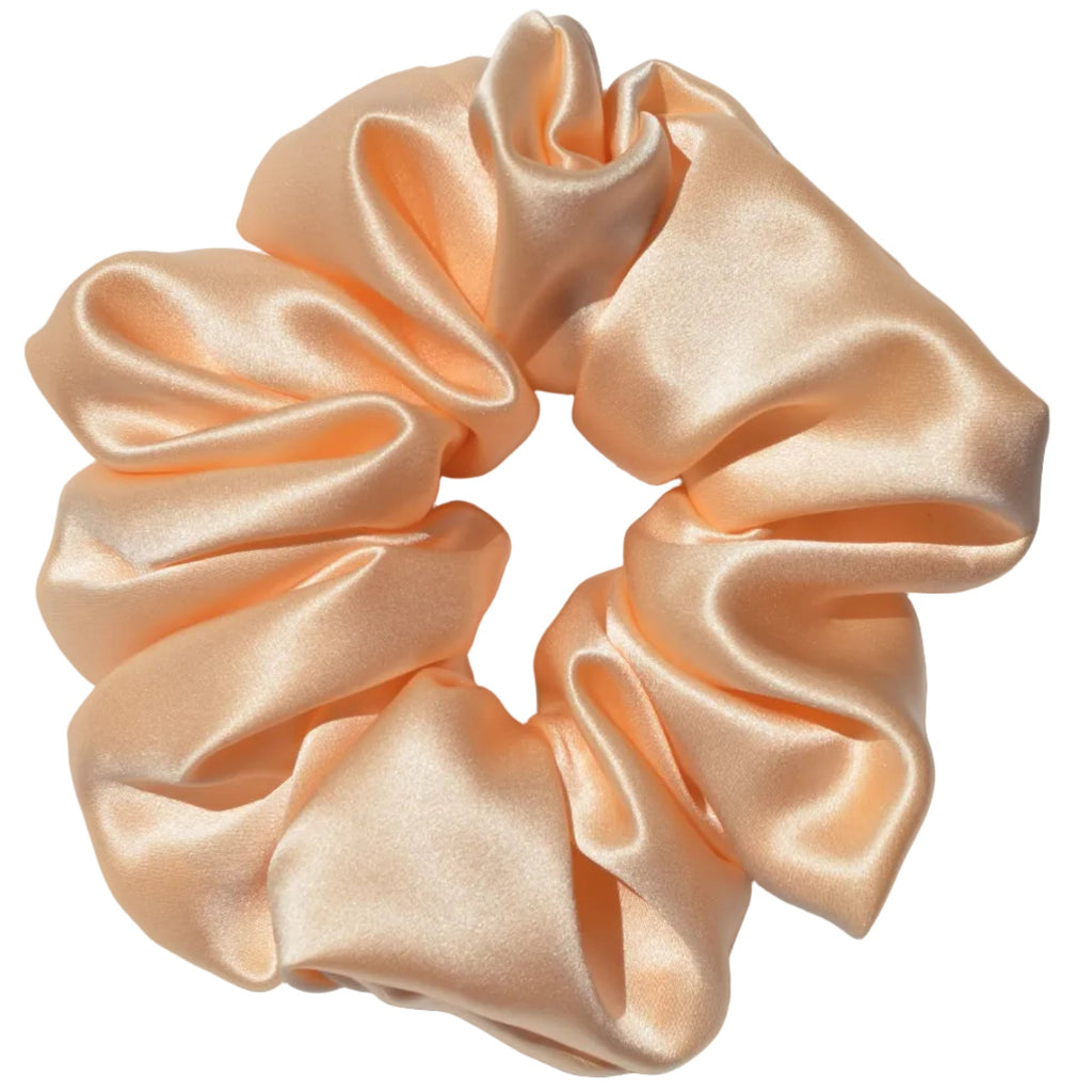 Light peach satin scrunchie on a light gray background