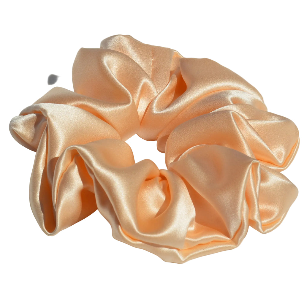 Large peach satin scrunchie on a light gray background
