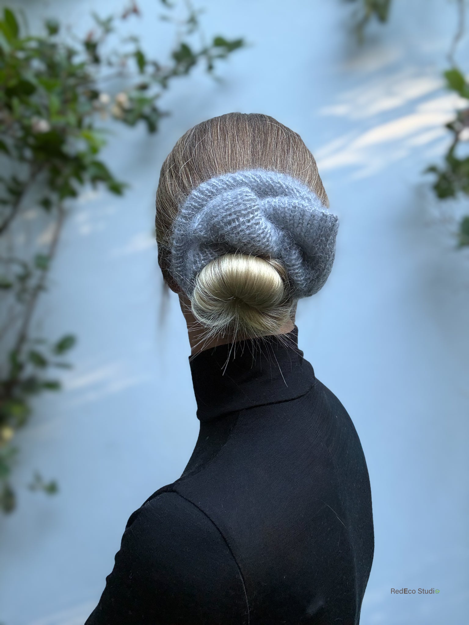 Person wearing a knitted scrunchie with a blurred background