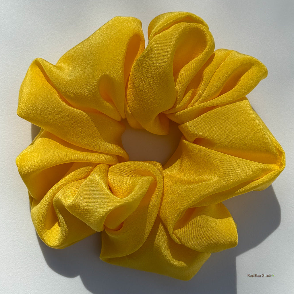 Large yellow silk scrunchie on a white background