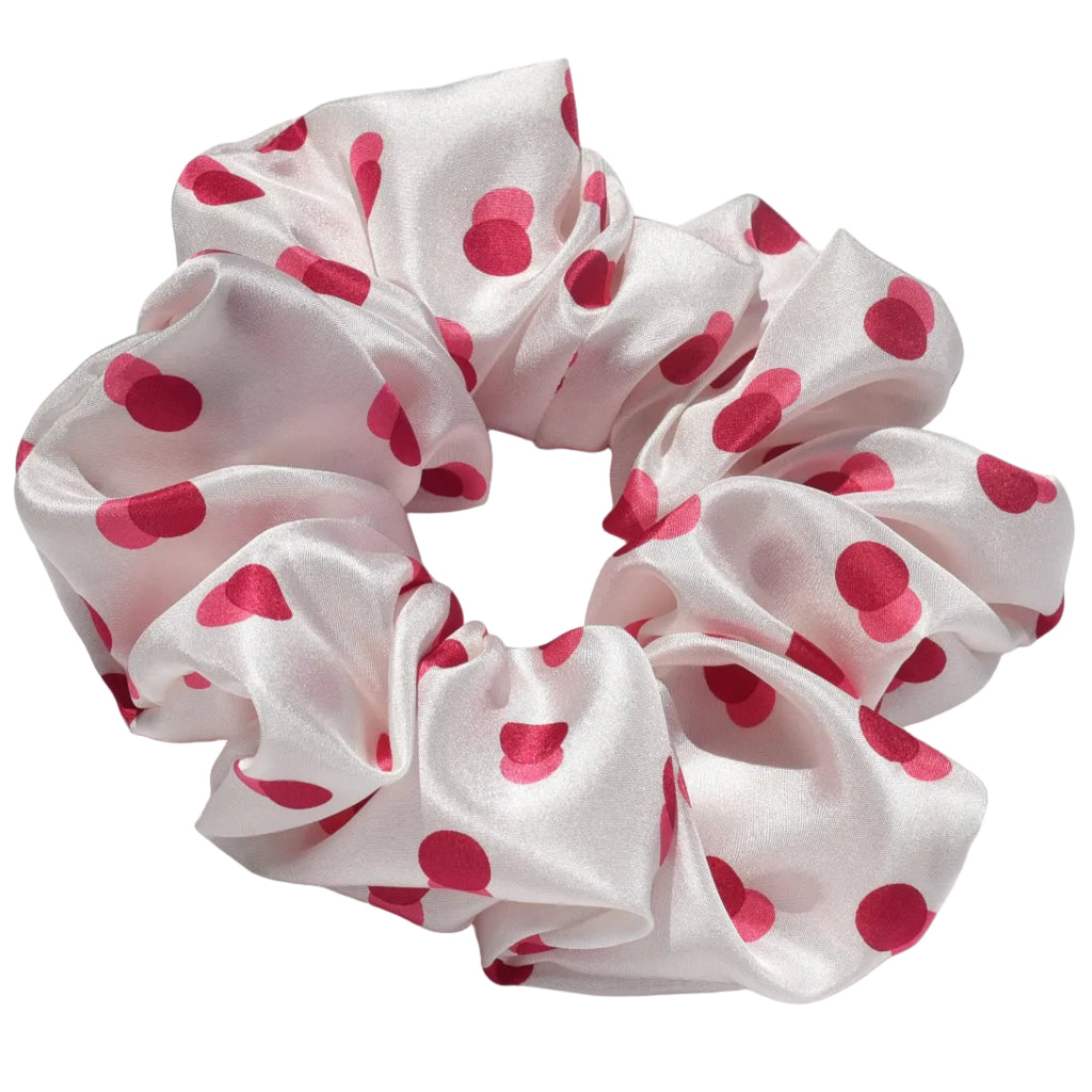 White scrunchie with pink polka dots  pattern on a white background
