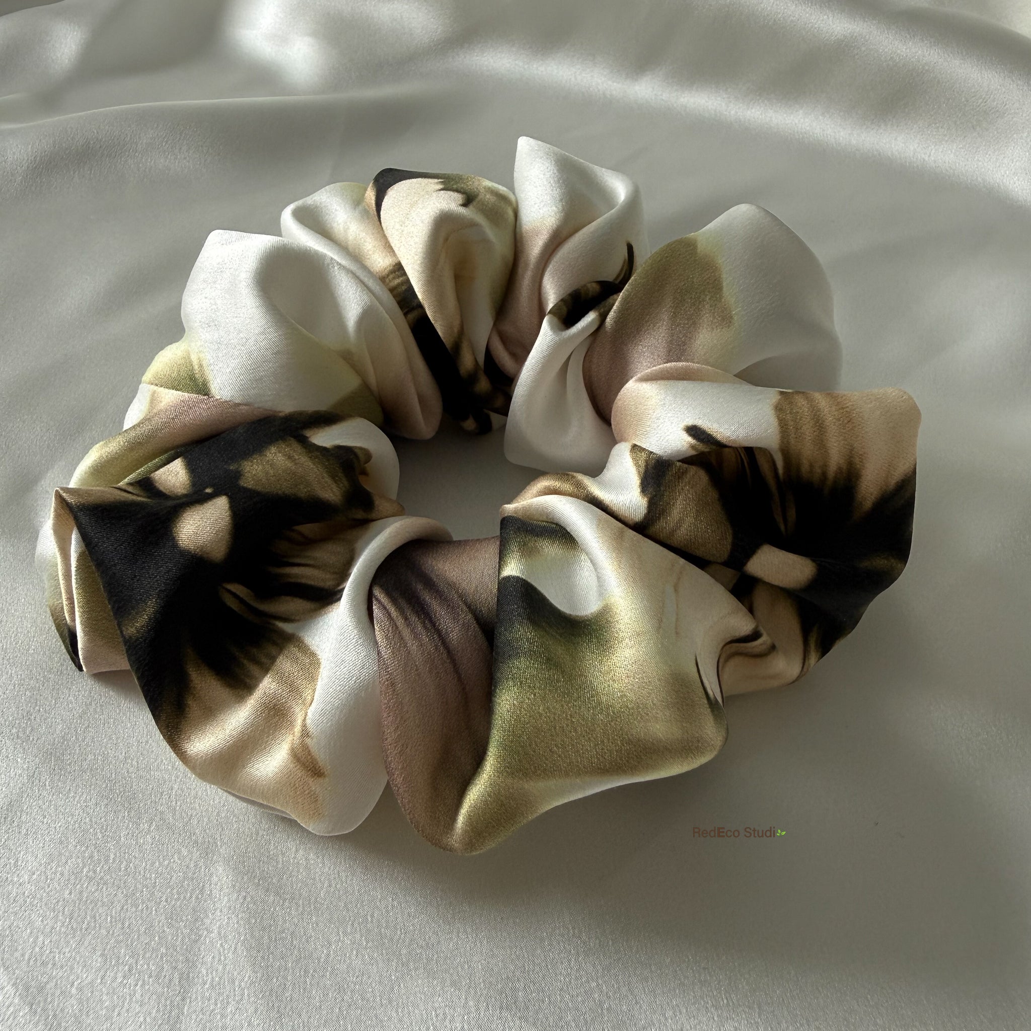 Silk scrunchies on a light fabric background