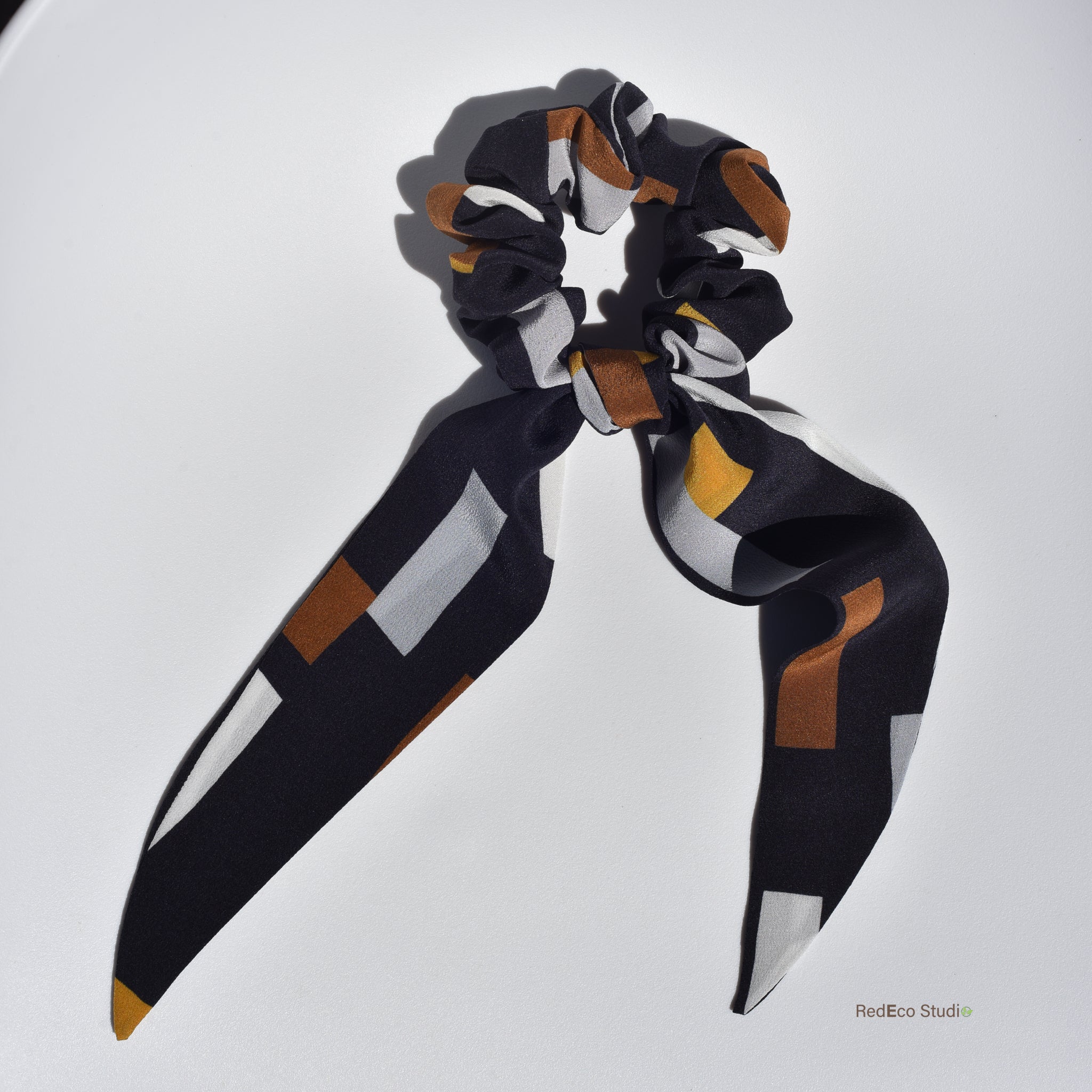 Scarf silk scrunchie with geometric pattern on a white background