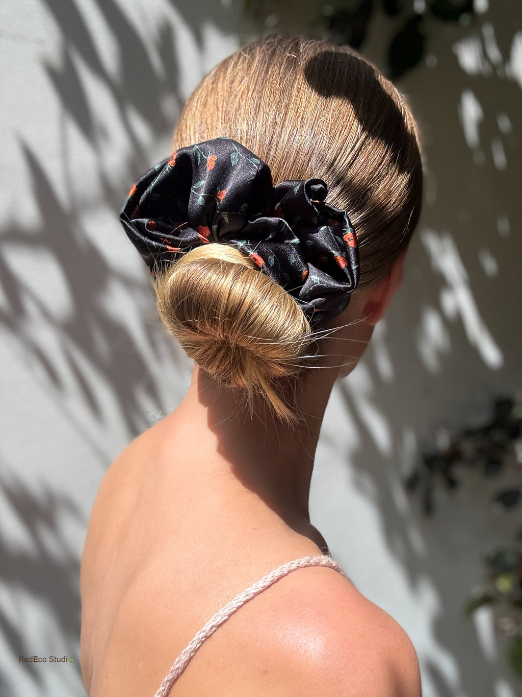 Oversized black floral silk scrunchie wrapped around a low bun
