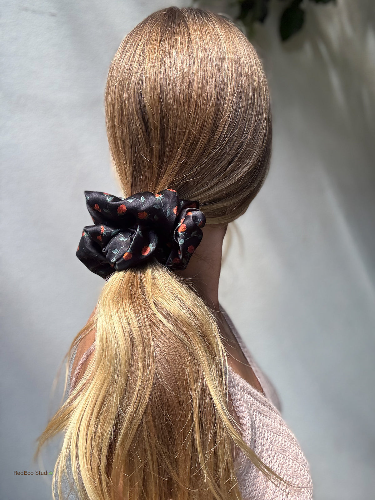 Ember Rose silk satin scrunchie holding a sleek low ponytail