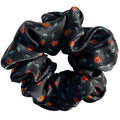 Ember Rose oversized silk satin scrunchie with tiny orange rosebuds and sage leaves on black, flat lay