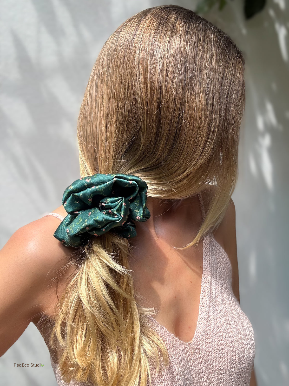 Emerald Posy oversized silk scrunchie on a low side ponytail worn over the shoulder, with a pink knit top