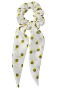 White regular size silk hair scrunchie with green polka dots on a white background