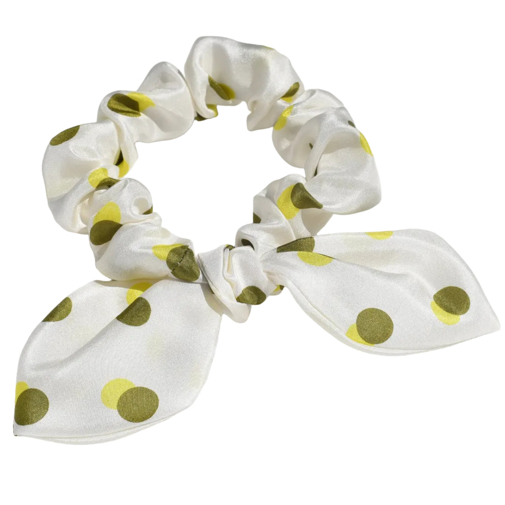 White mini silk scrunchie with green yellow polka dots on a white background