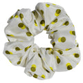 White large silk scrunchie with green polka dots on a white background
