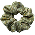 Matcha Daisy oversized silk crêpe de chine scrunchie, flat lay top view showing tiny cream and yellow daisies on sage green